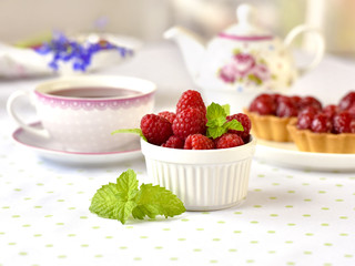 Raspberries with Fruit tart cakes on a table