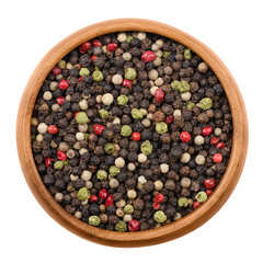 Mixed peppercorns in a wooden bowl on white background. Black, green, white and pink pepper. Dried seeds of Piper nigrum and Schinus molle, a spice, used  as seasoning. Isolated macro photo close up.