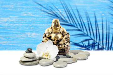 Laughing Buddha,zen stone,white orchid flowers.In the background is blurred wooden wall with palm shadow silhouette