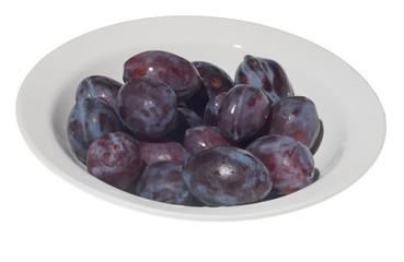 Plums in white plate on white background