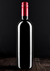 Bottle of red wine dark glass on wooden bacground