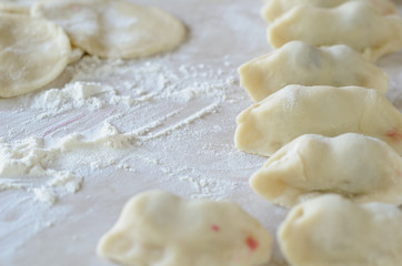 Fototapeta na wymiar The dough rolled with circles, sprinkled flour. Making of pierog.