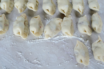 The dough rolled with circles, sprinkled flour. Making of pierog.