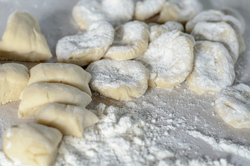 The dough rolled with circles, sprinkled flour. Making of pierog.