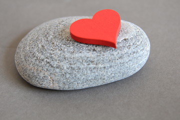 Fototapeta premium Love. Red heart on the stone background. Gray background. Heart heaviness. Heart healthy. 
