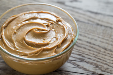 Bowl of peanut butter on the wooden table