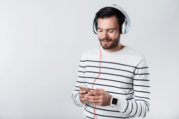 Satisfied bearded man listening to music.