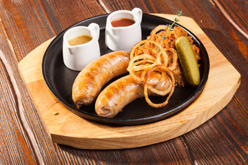 Fried sausages with sauces and potatoes