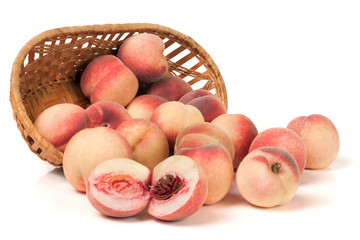 peaches in a wicker basket isolated on white background