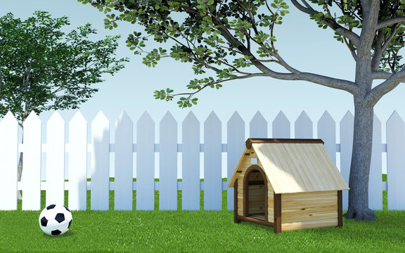 Wooden dog kennel under tree shade on green grass meadow with soccer ball and white wooden fence