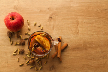 Closeup with free space of hot tea with apple, cinnamon and cardamom. Autumn healthy drink to warm yourself in cold weather. Vitamin beverage with spices.