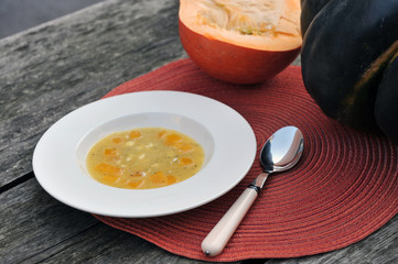 Pumpkin soup with two large pumpkins in the background.