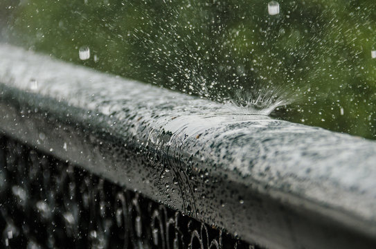 Drops Bouncing Off Metal Railing During Heavy Rain