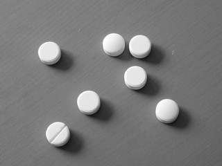 Pills on wooden table in black and white colors