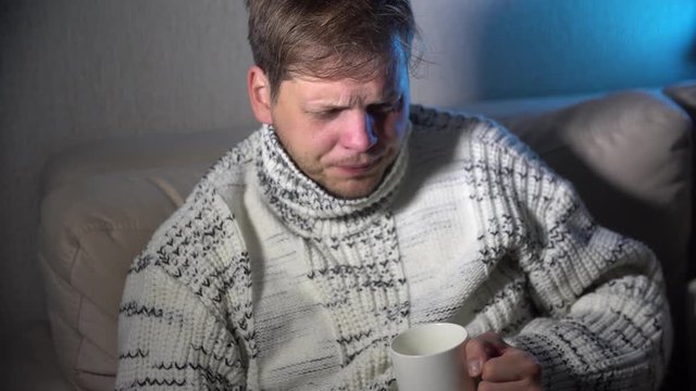 Sick man blowing his nose in the tissue, sick man snotty drinking warm healing tea