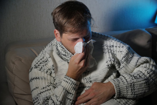 Sick man blowing his nose in the tissue, young ill man in bed

temperature feeling bad infected by winter grippe virus in flu and influenza health care concept

