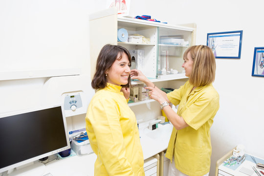 Due bellissime dottoresse in studio dentistico con il camice giallo 