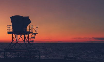 Vintage California sunset with life guard station silhouette - Powered by Adobe