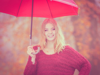 Fashion woman with umbrella relaxing in fall park.