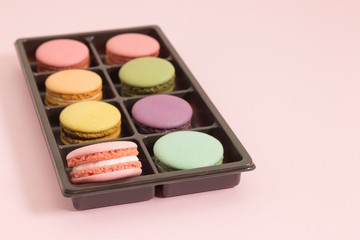 Sweet and colorful french macaroons or macaron on pink background, Dessert.