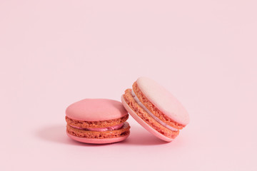 Sweet and colorful french macaroons or macaron on pink background, Dessert.