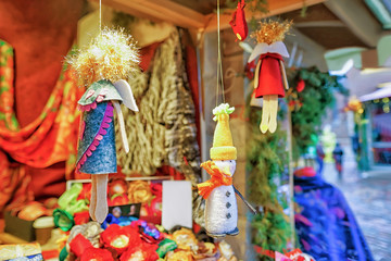Small handmade statues hanging on display at Riga Christmas market