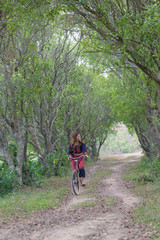 Fototapeta premium Young asian women rideing an old bike in field..