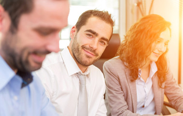 Young attractive businessman working at the office with associat