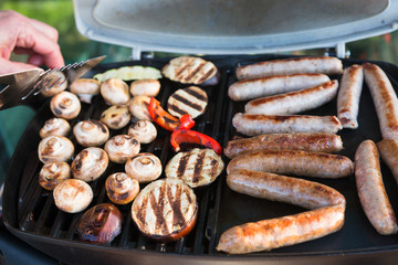 Grilled sausages and vegetables on barbeque