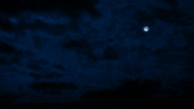 Moon In Night Sky With Clouds Passing