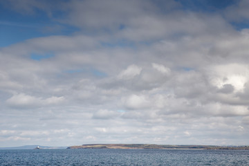 white fluffy clouds down by the sea