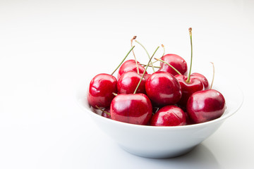 A bowl of cherries on a white background