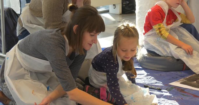 Smiling Educator Mum and Little Girl Painting Sitting on a Floor in Art Gallery People Have Fun Kindergarten Classroom Animators Entertain the Children