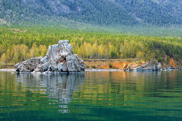 Colorful forest with reflection in water and rock