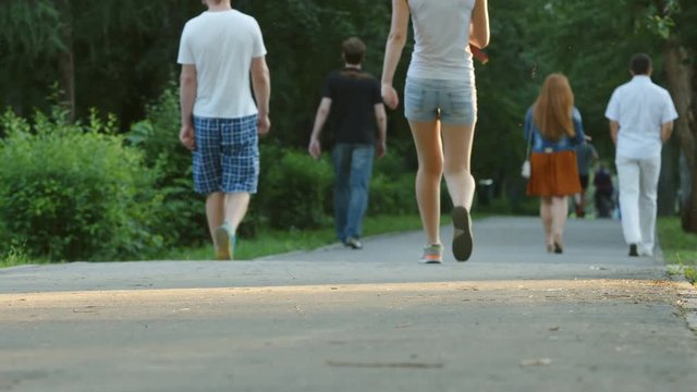 Young people walk in a park - feet level