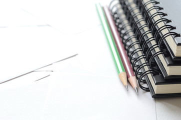 Note books and wooden pencils on white paper with copy space for text at left side,office supplies.
