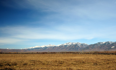 Fototapeta premium blue sky over the vast steppes, Tunka valley, mountains covered with snow, Sayan mountains. Used deep toning of the photo 
