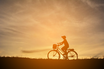 Fototapeta premium Silhouette a boy with bicycle at sunset