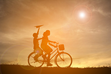Obraz na płótnie Canvas Silhouette women and boy playing on sunset