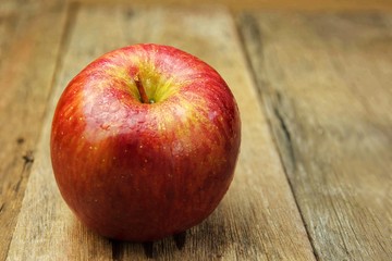 Red apples on on old wooden desk background.