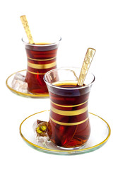 Turkish tea in the traditional glasses with delights on the white background