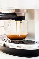 Cappuccino coffee preparing in glass cup with coffee machine