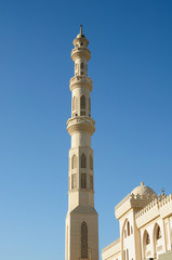 Fototapeta na wymiar tower minaret of muslim mosque in front of azure blue sky