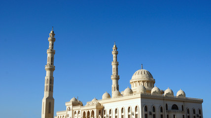 Fototapeta na wymiar tower minaret of muslim mosque in front of azure blue sky