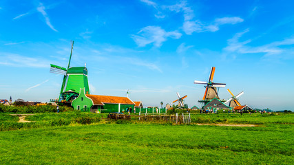 Fototapeta premium Fully operational historic Dutch Windmills along the Zaan River at the village of Zaanse Schans in the Netherlands