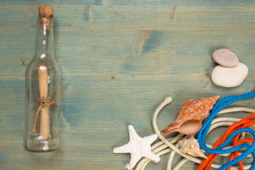 Summer background on wood with message in bottle, copy space