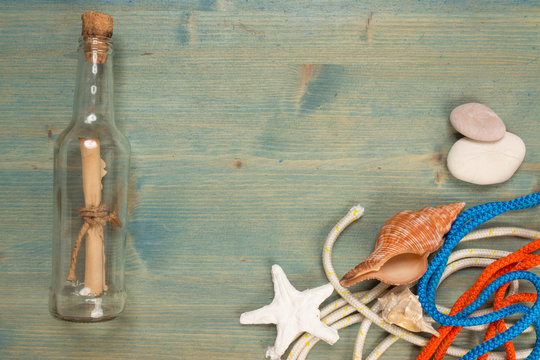 Summer background on wood with message in bottle, copy space