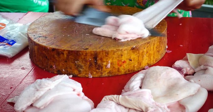 Close up of a woman cutting the skin off a pig in local market, Thailand 
