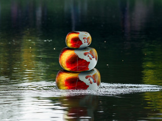 Glowing fire bulky stones in the water. Zen pyramid. Concept - stress, yoga, meditation, Zen