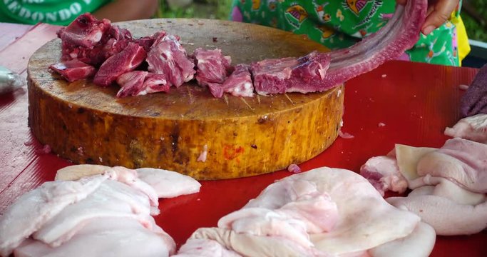 Close up of a woman chopped the bone off a pig in local market, Thailand 
